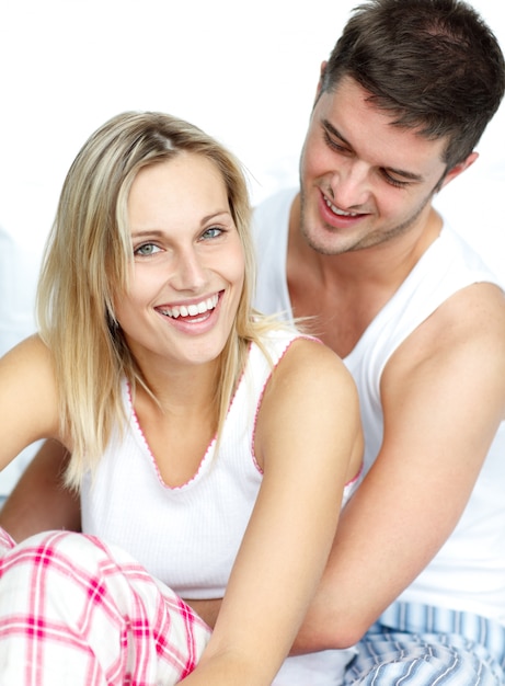 Man and woman sitting on bed