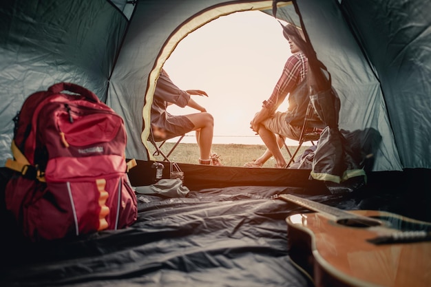 Photo man and woman sitting in chairs on camp.