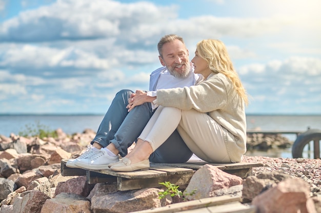 Man and woman sitting near sea talking