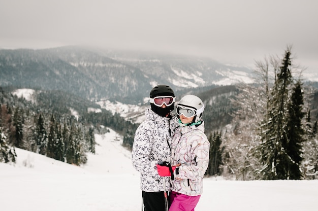 Uomo e donna in maschera da sci con gli sci sulla neve.