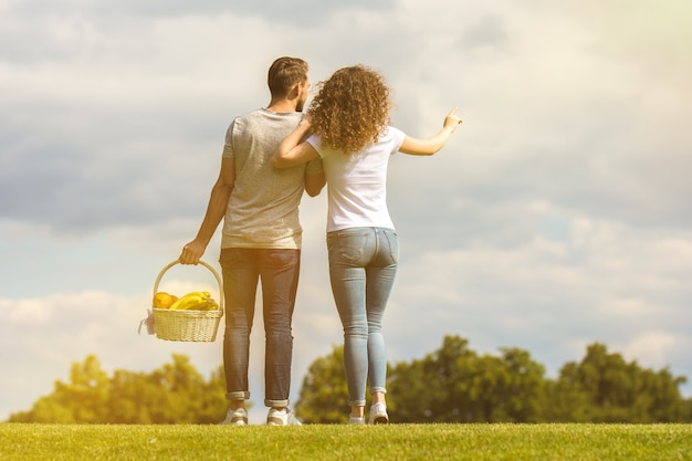 The man and woman stand in the grass