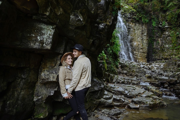 man and woman stand and hug on rocks, near tree, forest and lake. Landscape of an old industrial granite quarry. Canyon.