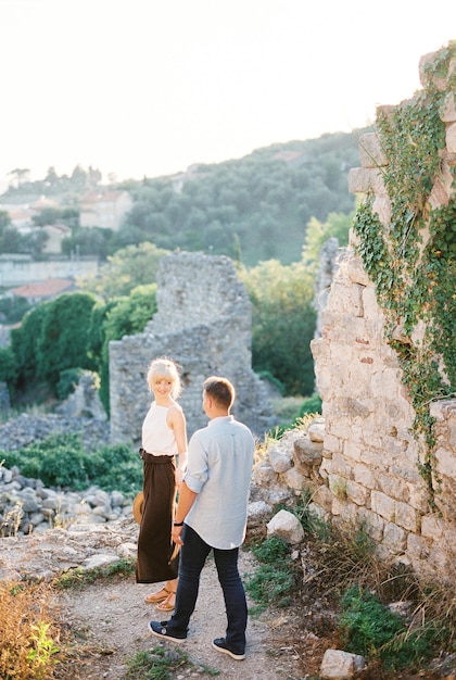 Man and woman stand on the ruins of a castle
