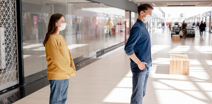 Photo man and a woman standing in a supermarket at a safe distance . concept of health protection.
