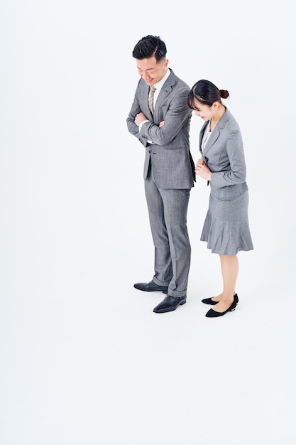 Man and woman in suits staring at the bottom of the screen