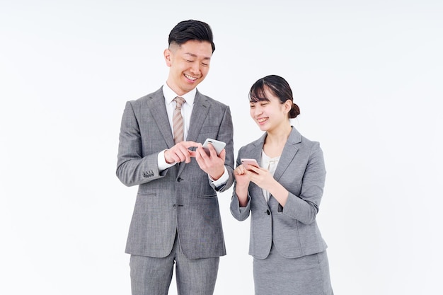 Man and woman in suits with smartphones
