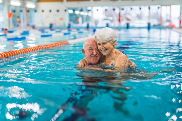 A man and a woman in a swimming pool hugging and smiling.