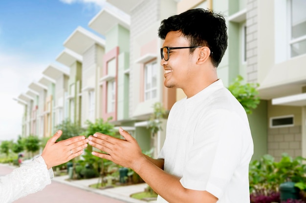 A man and a woman talking in front of a row of houses