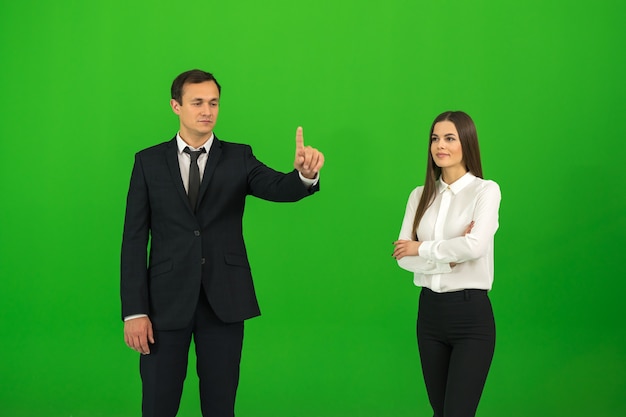 The man and woman touch the virtual screen on the green background