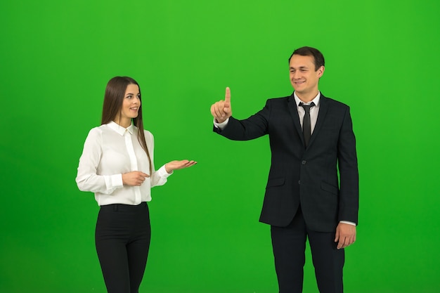 The man and woman touch the virtual screen on the green background