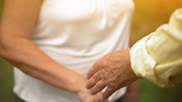 A Man And A Woman Touching Hands In The Garden