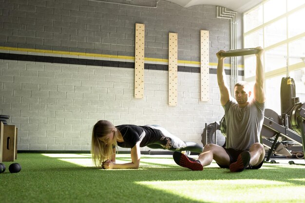 Photo man and woman training in gym together