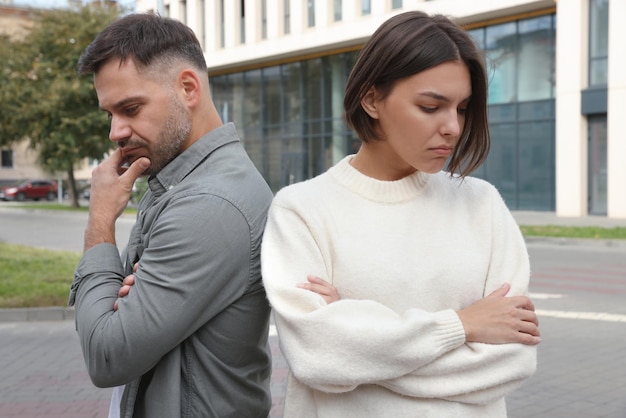 Man and woman turned away from each other outdoors Relationship problems