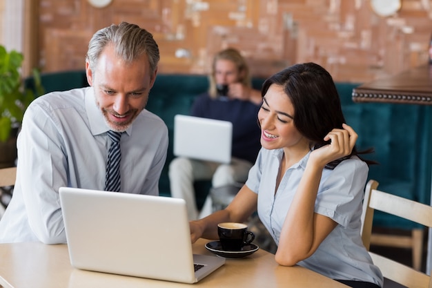 Man and woman using a laptop during meeting