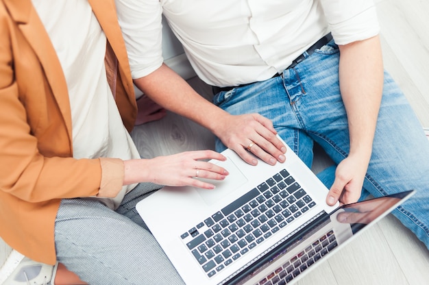 Uomo e donna che per mezzo del computer portatile