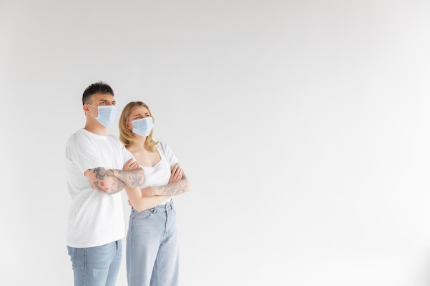 Man and woman wearing face mask standing from each other keeping social distancing avoiding