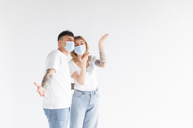 Man and woman wearing face mask standing from each other keeping social distancing avoiding