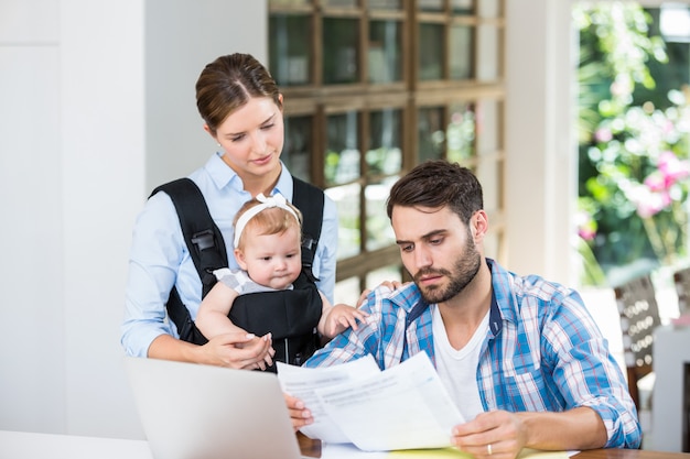 Man and woman with baby reading documents