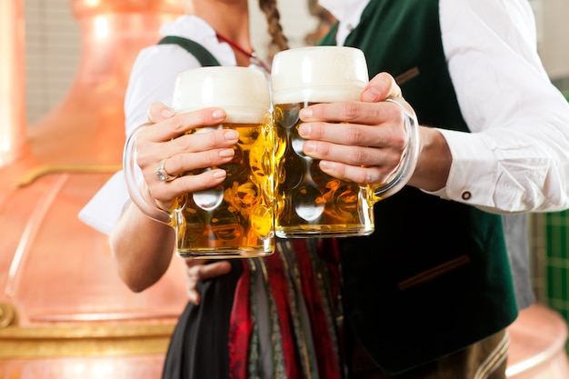 Man and woman with beer glass in brewery