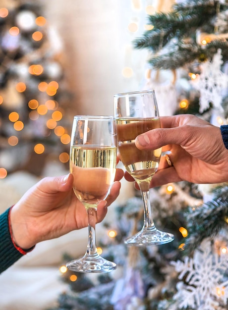 Man and woman with champagne in their hands near the Christmas tree Selective focus