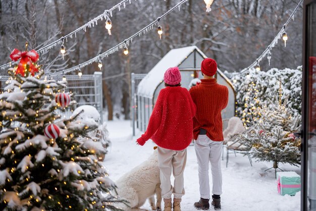 겨울 방학에 눈 덮인 뒷마당에서 개를 데리고 있는 남녀