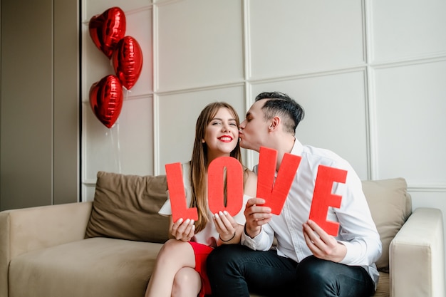 Man and woman with love letters in hands at home on couch