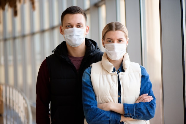 man and woman with medical face mask in airport