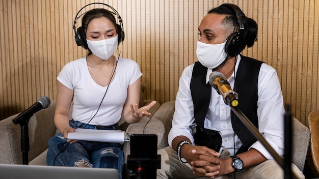 Man and woman with medical mask being live at the radio