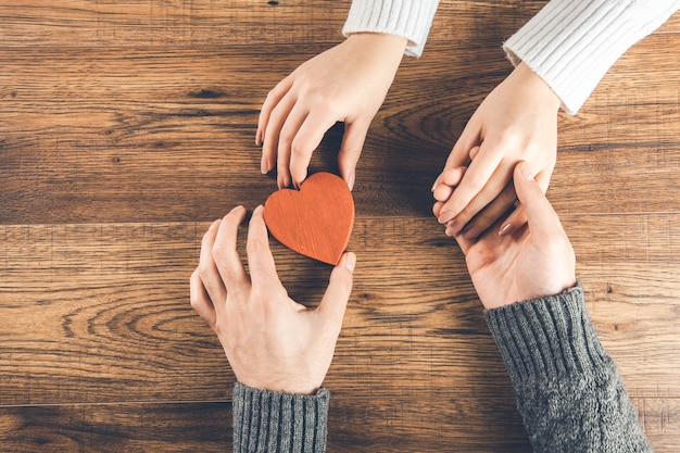 Man and woman with small heart on wooden