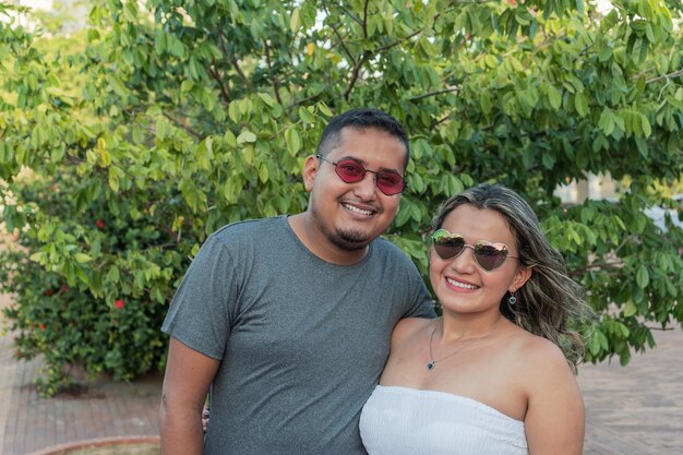 Мужчина и женщина в солнцезащитных очках, стоящих в парке