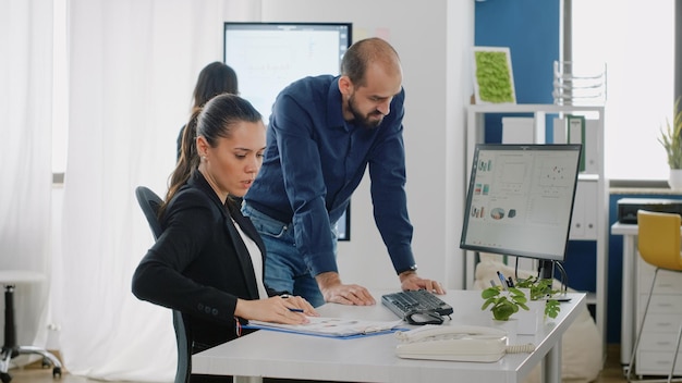 Man and woman working on business plan with data charts for industry development. Workmates using computer to design project with marketing and management strategy for corporate job