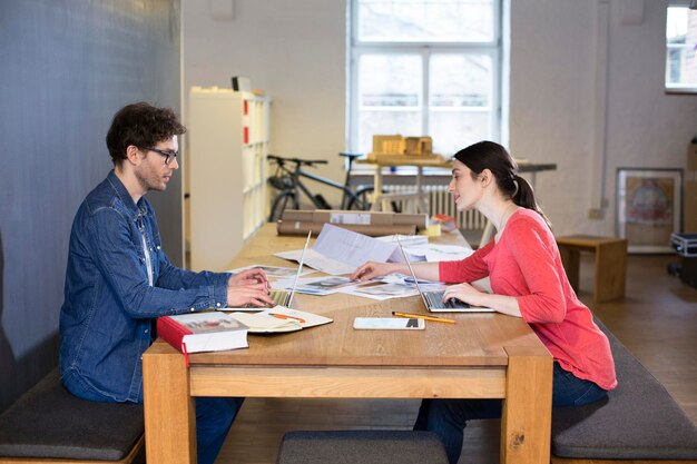 Man and woman working on project in office together