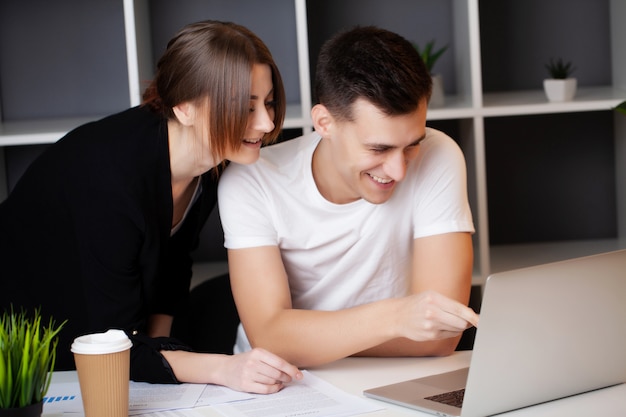 Man and woman working together on a project in the office