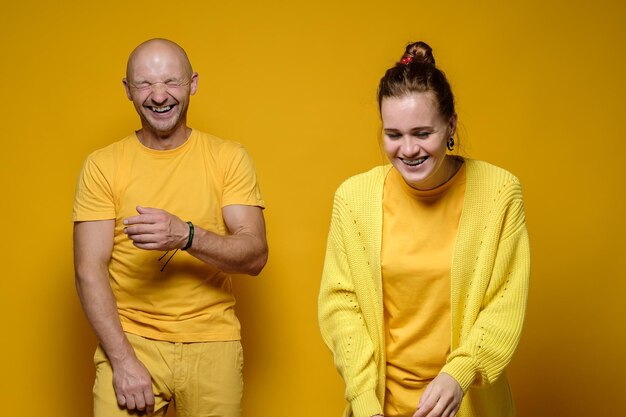 Man and a woman in yellow clothes laugh merrily