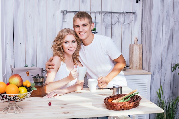 Man and woman young and beautiful couple in the kitchen home cook and have Breakfast together, helping each other