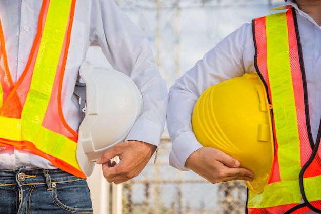 Man and Women Engineer holding hardhat safety Standing outdoor Teamwork management project