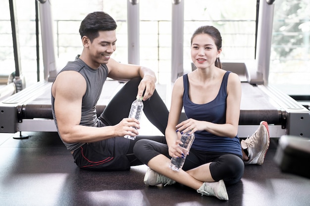 Man and women working out in gym together