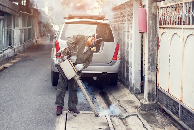 Man work fogging to eliminate mosquito for preventing spread dengue fever and zika virus