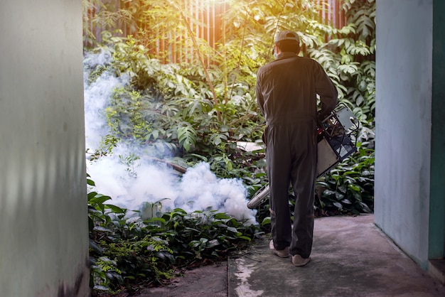 Man work fogging to eliminate mosquito for preventing spread dengue fever and zika virus