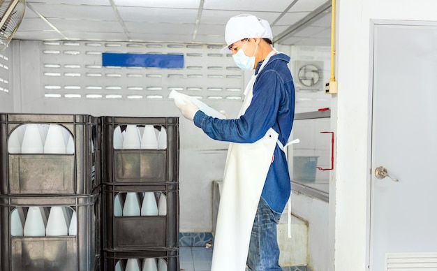 Man worker or quality inspector in workwear working in checking bottled in drink water factory