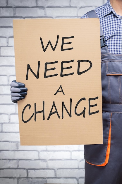 Man worker with we need a change placard Worker on strike