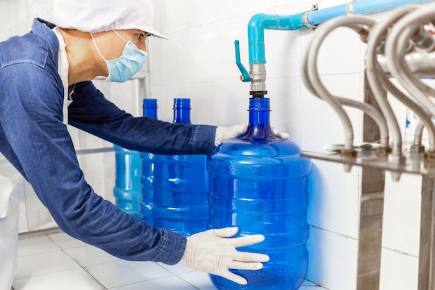 Man worker working blue gallon drinking water in a clean drinking water factory clean drinking water