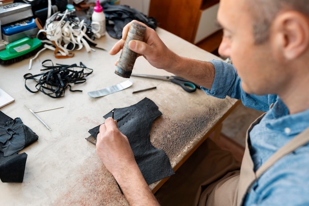 写真 革工房で一人で働く男