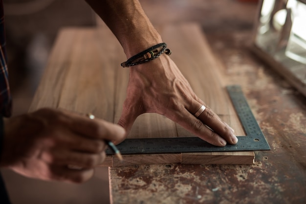 Photo man working as a carpenter in his own studio woodworking