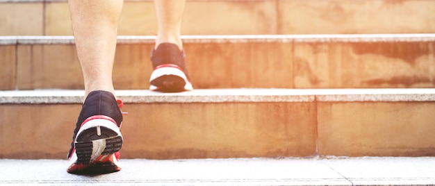 Man working closeup legs walking up the stairs in modern city\
in rush hour to work in office a hurry during the first morning of\
work stairway soft focus