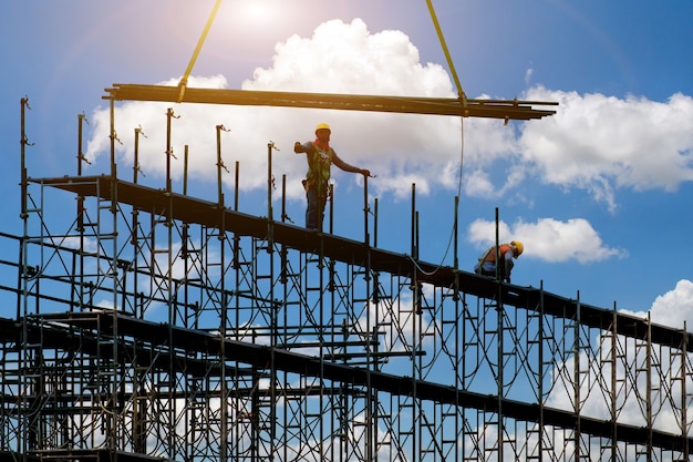 Uomo che lavora in cantiere con impalcatura e costruzione, ponteggi per fabbrica di costruzioni