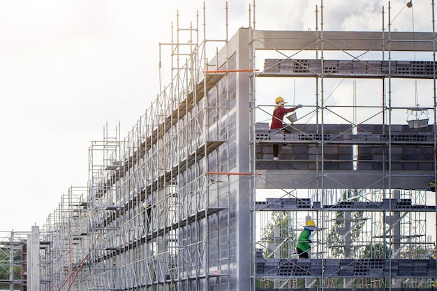 Man working on construction site with scaffold and building with sky backgroundscaffolding for construction factory