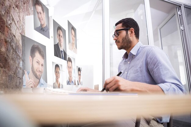 Foto uomo che lavora alla scrivania con computer e digitalizzatore contro le immagini del profilo