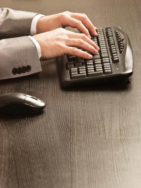 Man working at desk with a computer keyword