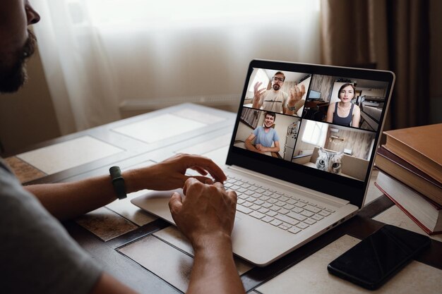 Man Working From Home Having Online Group Videoconference On Laptop